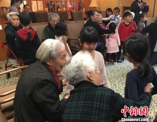 資料圖：北京一家養(yǎng)老機(jī)構(gòu)內(nèi)，老人們與幼兒園小朋友一起做游戲?！《叛?攝
