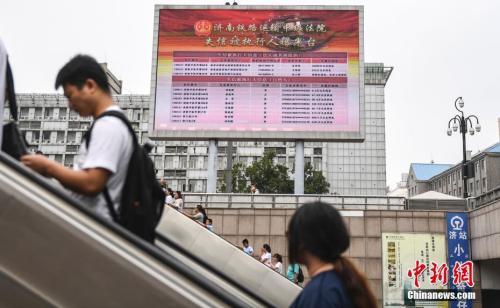資料圖：2017年8月23日，濟南火車站廣場大屏幕24小時循環(huán)播放失信被執(zhí)行人信息，引得許多旅客駐足觀看。 <a target='_blank' href='http://www.chinanews.com/'>中新社</a>記者 張勇 攝