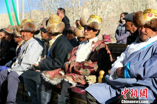 西藏阿里地區(qū)獨(dú)特的自然風(fēng)光及具有深厚文化底蘊(yùn)和舉世聞名的人文景觀，吸引著越來越多的游客走進(jìn)阿里，旅游業(yè)也讓當(dāng)?shù)孛癖姷玫皆絹碓蕉嗟膶?shí)惠。資料圖：阿里地區(qū)札達(dá)縣民眾在扶貧搬遷儀式上。札達(dá)縣委宣傳部供