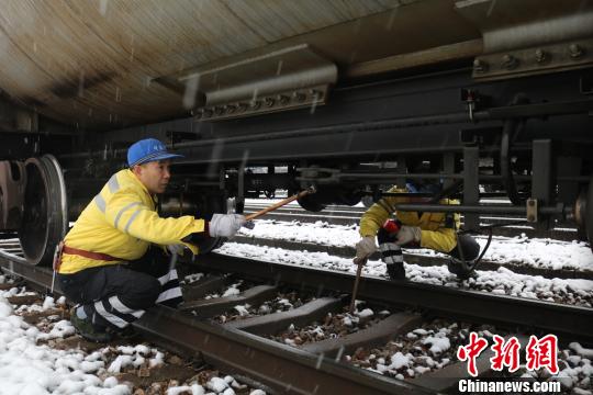 南京東車輛段貨車檢車員風(fēng)雪里按標(biāo)準(zhǔn)作業(yè)，保障運(yùn)輸安全。　劉寅 攝