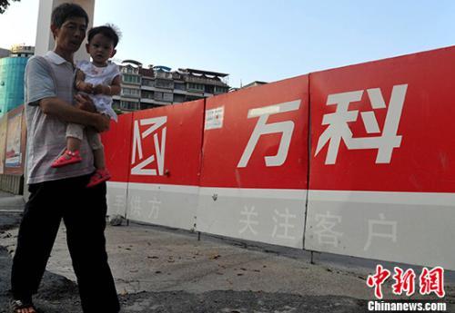 資料圖：民眾從萬科某樓盤工地旁經(jīng)過。<a target='_blank' href='http://www.chinanews.com/'>中新社</a>記者 張斌 攝
