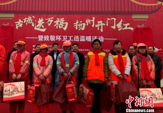 圖為現(xiàn)場向獲得“金掃帚”獎的環(huán)衛(wèi)工代表贈送春節(jié)禮包?！〈藜衙?攝