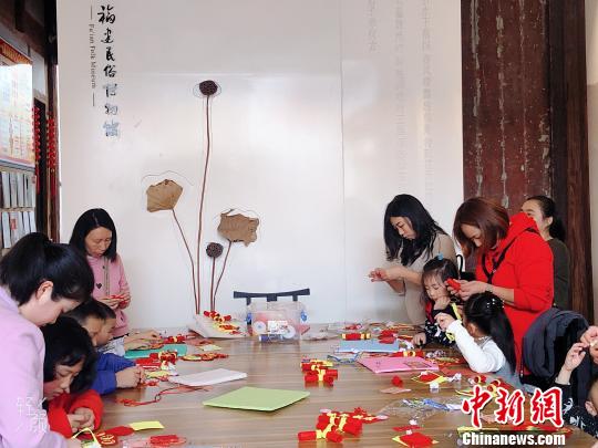 家長帶著小朋友參與趣味手工體驗活動?！∪~秋云 攝
