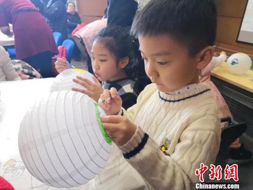 小朋友在花燈上勾勒自己對元宵佳節(jié)的理解與感悟 柴家權(quán) 攝
