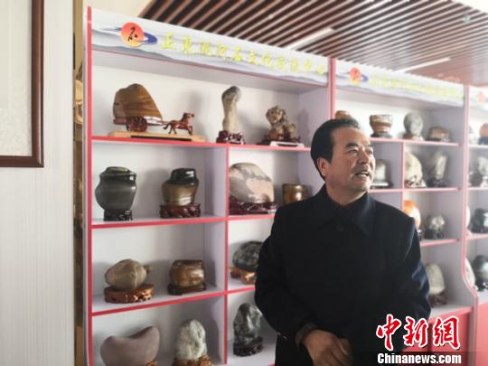 圖為博物館館長(zhǎng)邊正學(xué)介紹他收藏的石頭?！钅?攝