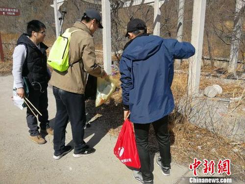 登山隊員們一手握夾子、一手拎袋子，開展登山撿拾垃圾活動。招嘉虹/攝 招嘉虹 攝