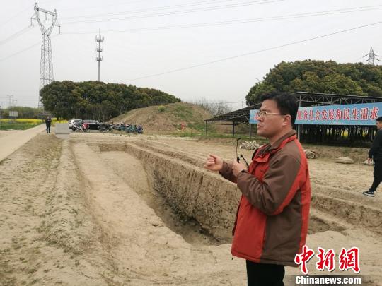 周潤墾在介紹發(fā)掘出的古河道遺址?！＄娚?攝