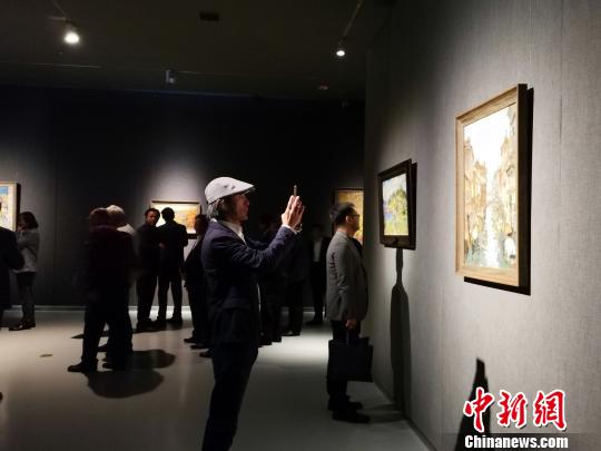 圖為，在“印象山東——俄羅斯油畫家寫生作品展”上，觀眾在喜歡的作品前駐足觀賞、拍照。　孫宏瑗 攝