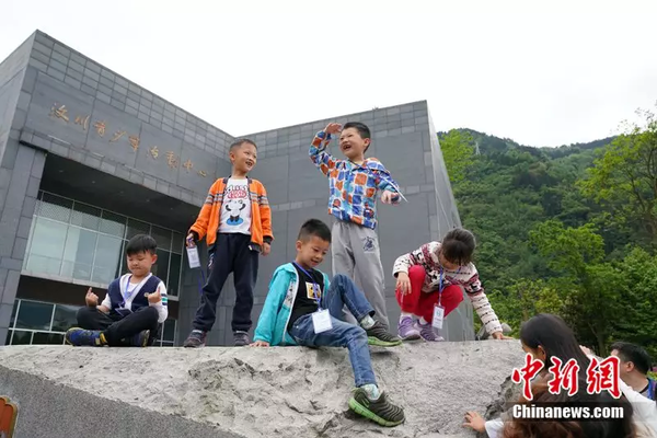 2018年4月22日，孩子們在汶川縣青少年活動中心前玩耍。中新社記者 毛建軍攝