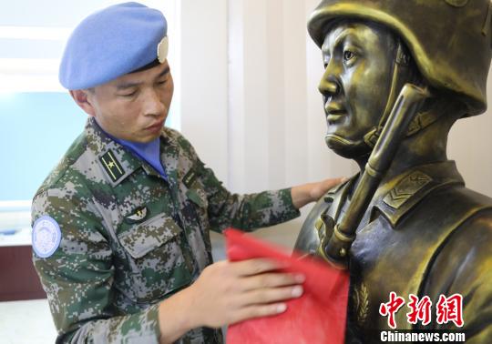 卞龍擦拭申亮亮烈士的雕像?！钤傩?攝