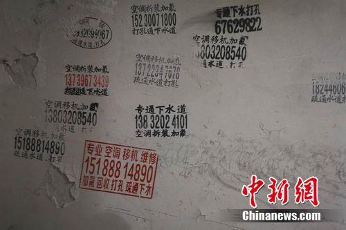 圖為北京一小區(qū)樓道內(nèi)的空調(diào)維修小廣告。 謝藝觀 攝