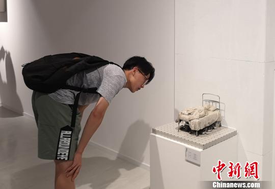 圖為觀眾觀看小尺度具象雕塑作品?！①t 攝