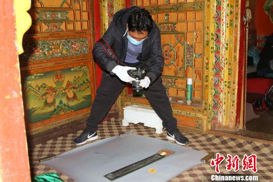 圖為西藏自治區(qū)古籍保護(hù)中心古籍保護(hù)部副主任才洛采集古籍影像信息。　趙朗 攝