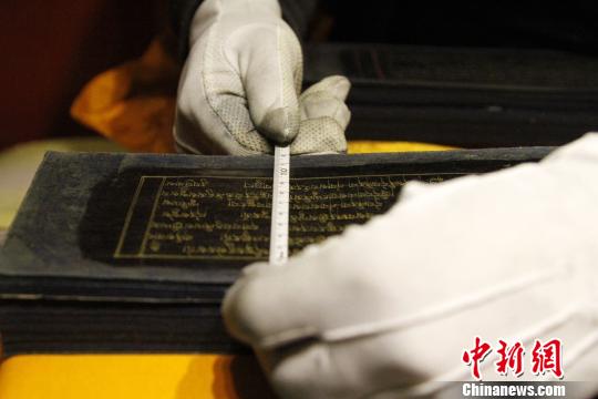 圖為羅布林卡管理處工作人員測量古籍尺寸?！≮w朗 攝