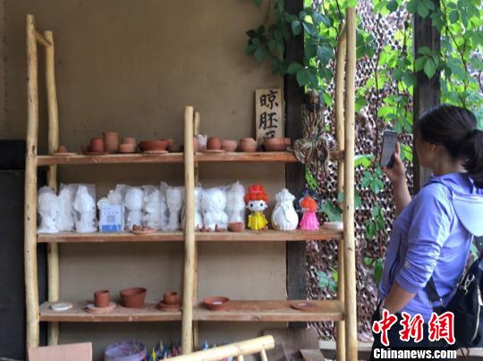 圖為月牙泉小鎮(zhèn)“敦煌彩陶”門(mén)口晾胚區(qū)吸引當(dāng)?shù)厝伺恼樟裟??！堟?攝