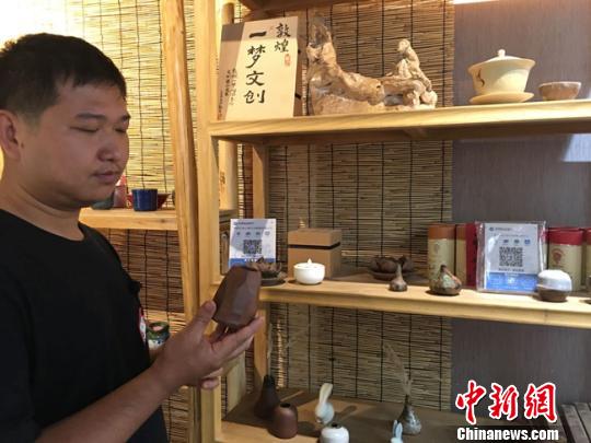 圖為月牙泉小鎮(zhèn)上的敦煌文化癡迷者葉金盛展示文創(chuàng)產(chǎn)品?！堟?攝