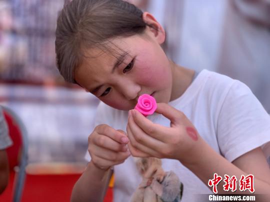 圖為小女孩正在用米塑捏玫瑰花?！O睿 攝