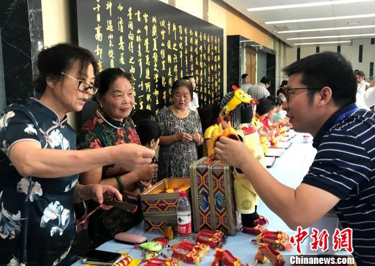圖為“秦觀故里”高郵三垛七夕習俗“巧娘娘送巧”——心靈手巧的婦女將自己一針一線手工制作的虎鞋送給孩子。　崔佳明 攝