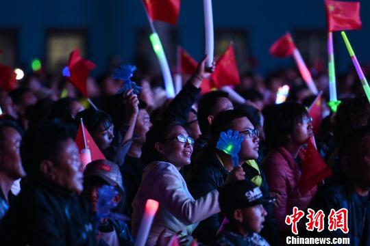 圖為當?shù)孛癖娪^看演出?！『闻罾?攝
