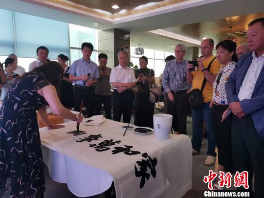 圖為，慶祝新中國成立70周年外國專家座談會暨駐濟外國人才中秋節(jié)沙龍觀上，外國專家觀看書法表演?！O宏瑗 攝