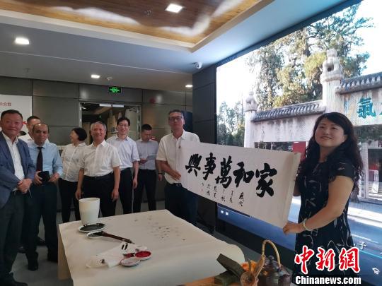 圖為，慶祝新中國成立70周年外國專家座談會暨駐濟外國人才中秋節(jié)沙龍觀上，外國專家展示獲贈書法作品?！O宏瑗 攝