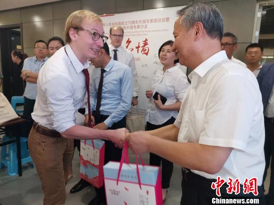 圖為，慶祝新中國成立70周年外國專家座談會暨駐濟外國人才中秋節(jié)沙龍觀上，外國專家獲贈中秋月餅?！O宏瑗 攝