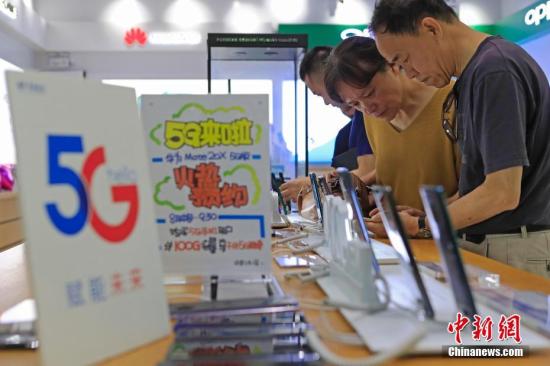 8月16日，民眾在中國電信上海營業(yè)廳內(nèi)，辦理5G手機和網(wǎng)絡相關業(yè)務。當日，中國電信上海公司推出“購5G手機，享5G網(wǎng)絡”的5G體驗活動。凡8、9月購買電信5G手機的客戶，可訂購每月贈送100GB的國內(nèi)5G體驗流量包。同時發(fā)布兩款電信5G手機終端，華為Mate 20X 5G版、中興天機Axon 10 Pro 5G版在15家電信營業(yè)廳和20家連鎖賣場同步開啟銷售。圖為市民在咨詢5G手機和網(wǎng)絡相關業(yè)務。 殷立勤 攝