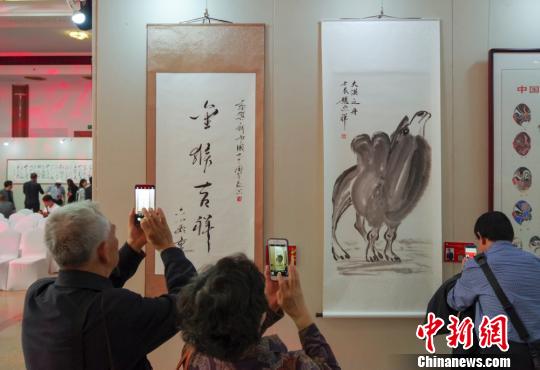9日，觀眾在“慶祝中華人民共和國(guó)成立70周年——影視藝術(shù)家優(yōu)秀書(shū)畫(huà)作品展”上參觀六小齡童的書(shū)法作品《金猴吉祥》和趙忠祥的畫(huà)作《大漠之舟》?！?lt;a target='_blank' href='http://www.chinanews.com/'>中新社</a>記者 賈天勇 攝