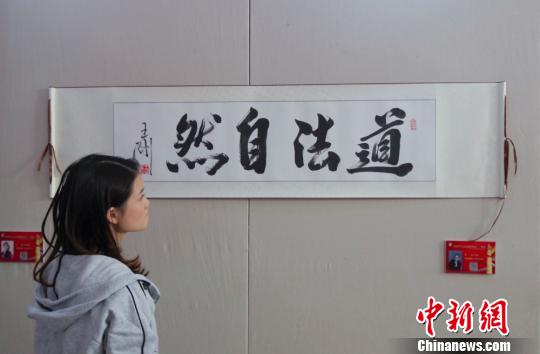 9日，觀眾在“慶祝中華人民共和國(guó)成立70周年——影視藝術(shù)家優(yōu)秀書(shū)畫(huà)作品展”上參觀王剛的書(shū)法作品《道法自然》?！?lt;a target='_blank' href='http://www.chinanews.com/'>中新社</a>記者 賈天勇 攝