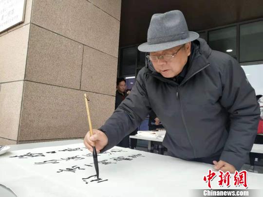圖為中國美術(shù)家協(xié)會副秘書長、中國美術(shù)家協(xié)會理事李榮海進行現(xiàn)場書法創(chuàng)作?！◆?shù)り?攝