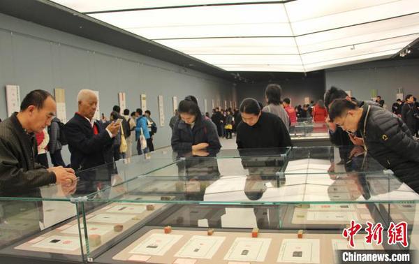 圖為觀眾在展廳內(nèi)欣賞篆刻作品?！≮w曉 攝
