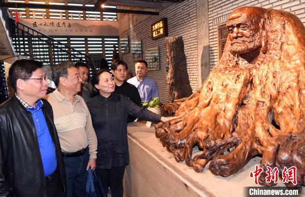 來(lái)賓觀看展出的中國(guó)工藝美術(shù)大師林學(xué)善代表作品《達(dá)摩》。　記者劉可耕 攝