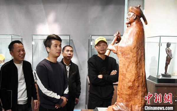 觀眾觀看由中國(guó)工藝美術(shù)大師林學(xué)善創(chuàng)作的木雕作品《林則徐》?！∮浾邉⒖筛?攝