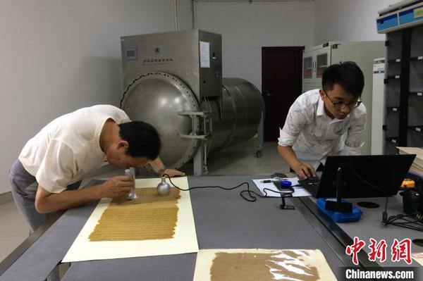 技術(shù)人員對“圣旨”原件進行分析采樣。(資料圖) 鐘欣 攝