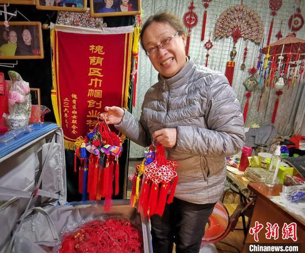 濟南結(jié)藝非遺傳承人胡立華向記者展示自己將帶往塞爾維亞廟會活動上的中國結(jié)作品?！≮w曉 攝