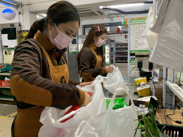 圖為美團(tuán)買菜員工為用戶分裝訂單菜品。