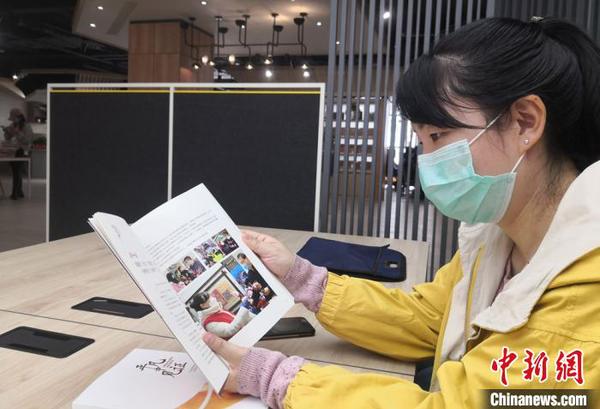 圖為社區(qū)工作人員閱覽書籍?！⒂裉?攝