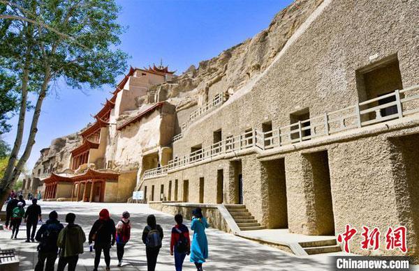 游客預(yù)約成功后，在采取了體溫測量、佩戴口罩等防控措施后，有序進(jìn)入敦煌莫高窟景區(qū)參觀游覽?！⊥醣筱y 攝