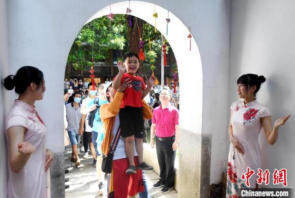 福州市民體驗頭頂狀元道的門梁中間懸掛的粽子，寓意“粽狀元，一舉高粽”。　記者劉可耕 攝
