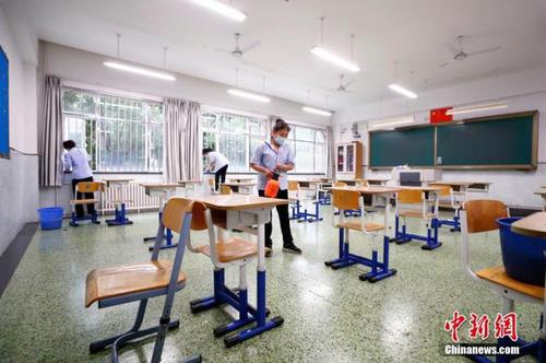 圖為7月3日北京十二中保潔人員對(duì)考場(chǎng)及走廊進(jìn)行清掃、消毒。 <a target='_blank' href='http://www.chinanews.com/'>中新社</a>記者 富田 攝