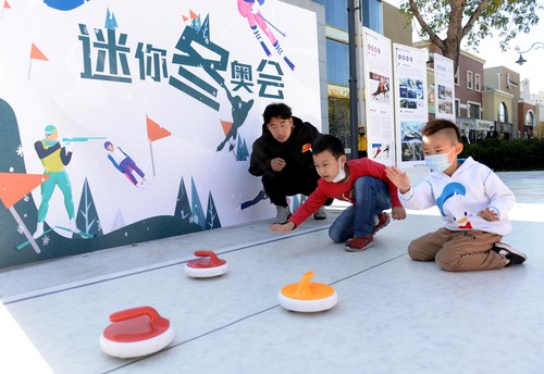 民眾在冬奧體驗互動區(qū)體驗冰壺迷你冬奧活動。