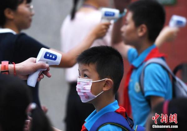 資料圖：工作人員為學生測量體溫。 中新社記者 陳超 攝