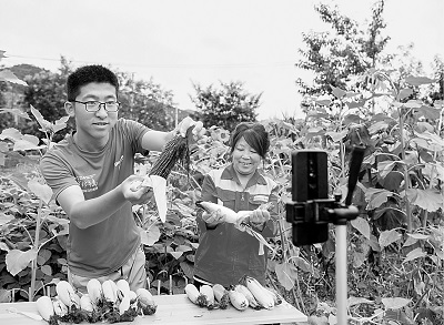 山西平順縣南坡村大學(xué)生王亞鵬（左）回村創(chuàng)業(yè)成為“新農(nóng)人”，圖為他正在直播銷售農(nóng)產(chǎn)品。新華社發(fā)
