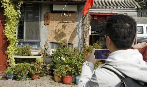 ▲一名游人在鐘樓灣胡同內(nèi)參觀拍攝。新華社記者李欣 攝